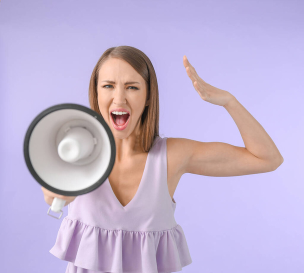 Агрессивная молодая женщина с мегафоном на цветном фоне
 - Фото, изображение