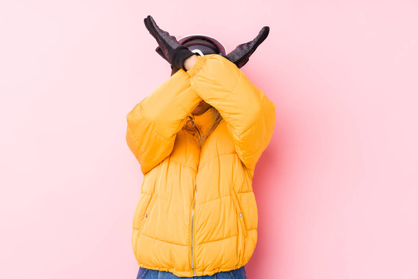 Young caucasian woman wearing a ski clothes in a pink background keeping two arms crossed, denial concept. - Foto, Imagem