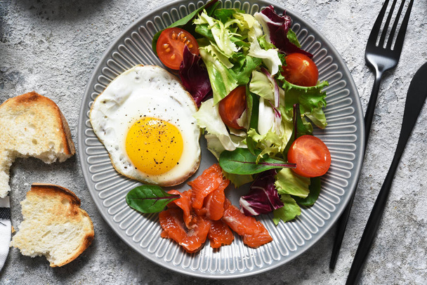 Classic breakfast - fried eggs with salad and salmon  - Zdjęcie, obraz