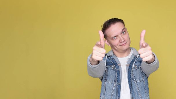 Stylish cool emotional guy in denim casual clothes on bright yellow background - Foto, immagini