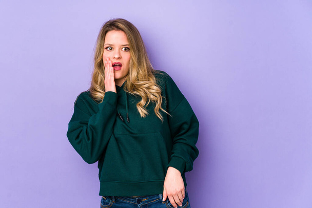 Young caucasian woman isolated on purple background being shocked because of something she has seen. - Photo, Image