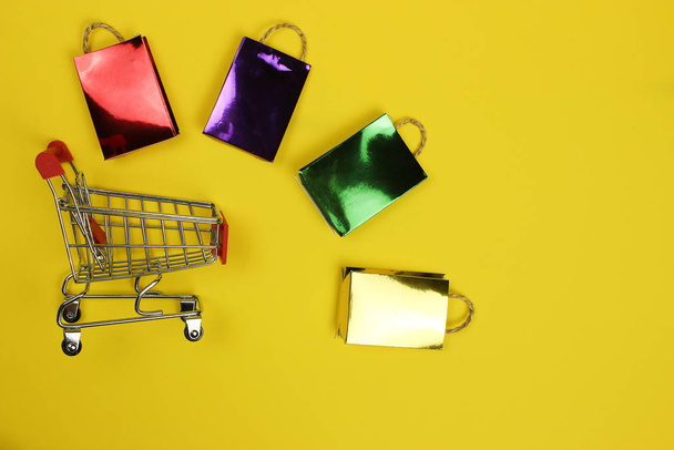 Shopping bag colorate e carrello supermercato, carrello. Dipendenza dallo shopping, amante dello shopping o concetto di shopping
 - Foto, immagini