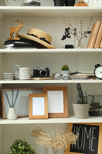 White shelving unit with photo frames and different decorative elements - Valokuva, kuva