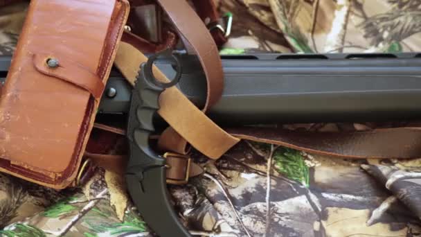 vista de cerca de la escopeta de caza negro y cuchillo de karambit en el fondo de camuflaje
 - Metraje, vídeo