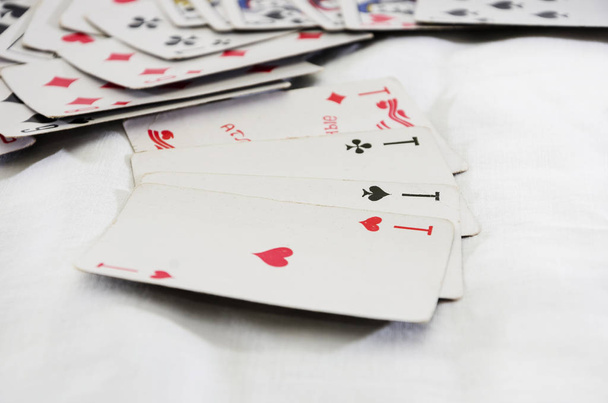 Чотири аси на білому тлі та розкидані ігрові картки
. - Фото, зображення