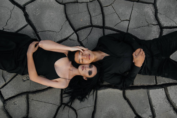 An Asian couple in love hugs while lying on the ground. Back background - Foto, imagen