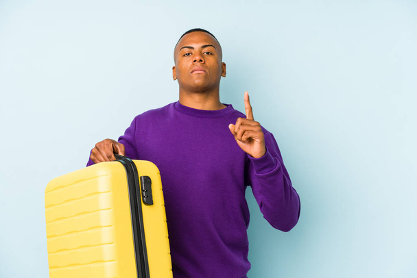 Молодой путешественник, держащий чемодан, на котором изображен номер один с пальцем.
. - Фото, изображение