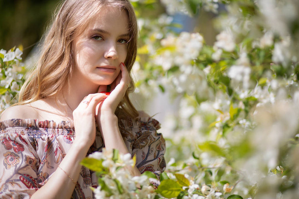 Portrait of a beautiful romantic blonde girl in a blooming garden - Fotoğraf, Görsel