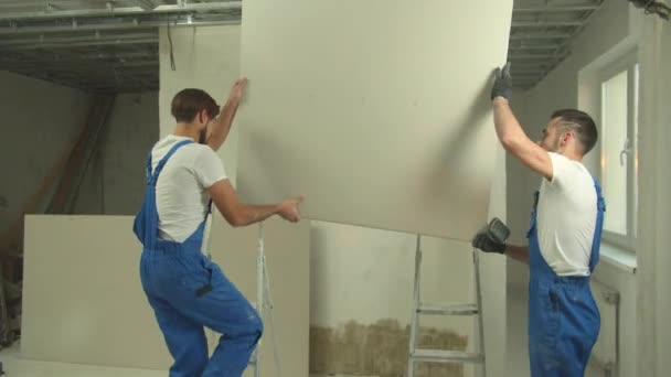 Opraváři v uniformě nainstalují panel na strop - Záběry, video