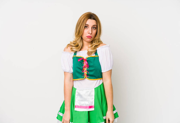 Young woman wearing a saint patricks day clothes isolated shrugs shoulders and open eyes confused. - Photo, Image
