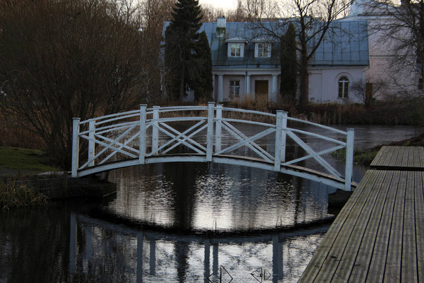 Su üzerinde ahşap köprü, şehir bahçesindeki sudaki yansıma. - Fotoğraf, Görsel
