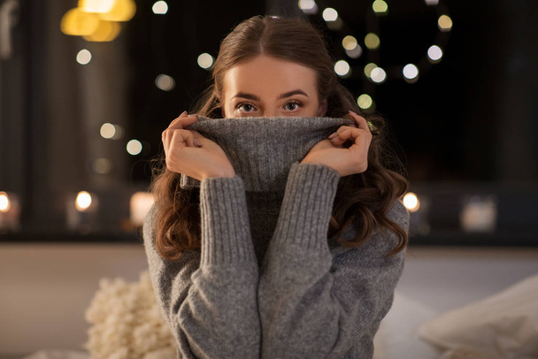 young woman in woolen sweater at home at night - Fotó, kép