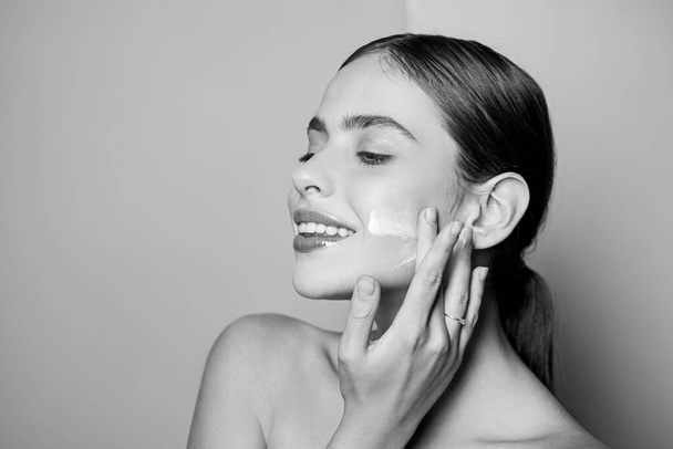 Facial care for female. Keep skin hydrated regularly moisturizing cream. Fresh healthy skin concept. Taking good care of her skin. Beautiful woman spreading cream on her face. Skin cream concept - Φωτογραφία, εικόνα