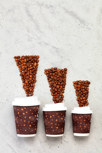 異なるコーヒー容量の3つの紙カップの反対コーヒー豆,垂直画像. - 写真・画像