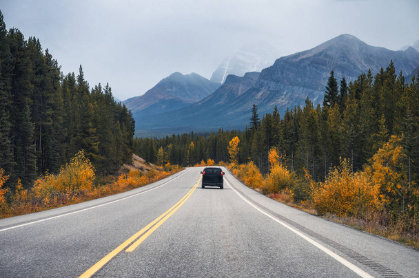 Viaje panorámico por carretera con montaña rocosa y coche trasero en otoño
 - Foto, Imagen