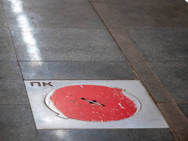 Požární poklopy na stanici metra Moskva. Červené kryty na podlaze plošiny u studní s požárními hydranty v metru - Fotografie, Obrázek