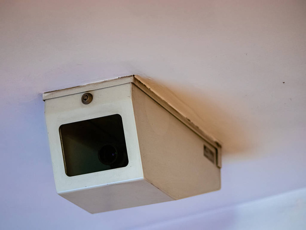 Búra megfigyelő kamera egy védő acél fehér lepel átlátszó ablakkal. Cctv videokamera a fehér mennyezeten a metró metró zárt dobozban egy zár - Fotó, kép
