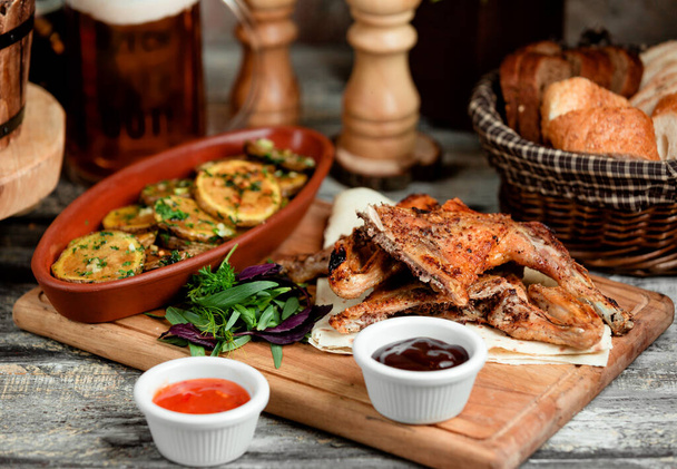 grilled chicken parts served with roasted potato slices and sauces - Φωτογραφία, εικόνα