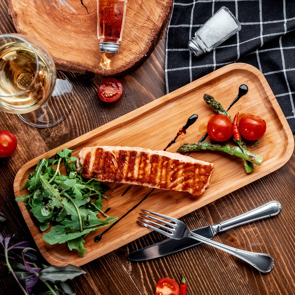 fried salmon with vegetables on wooden board top view - Zdjęcie, obraz