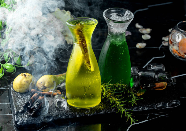 a glass bottle with pear cocktail with pear slices - Фото, зображення