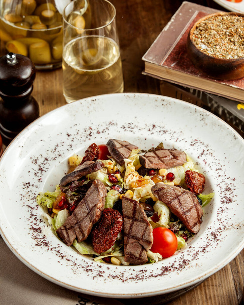 grilled beef salad with lettuce corn cherry tomato and raisins - Fotografie, Obrázek