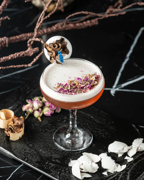 top view of foamy cocktail garnished with rose petal pieces and egg shells - Fotó, kép