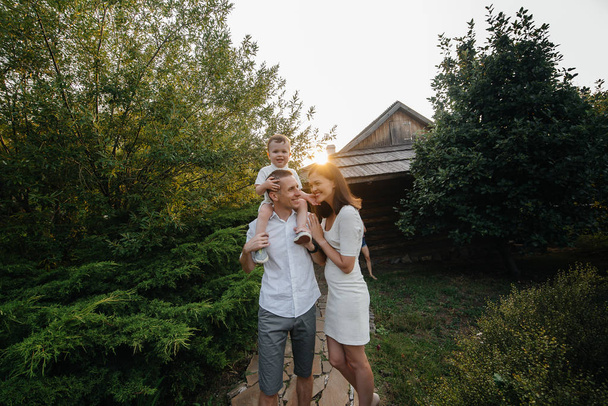 Happy family with their son walking in the Park at sunset. Happiness. Love - Фото, изображение