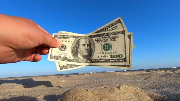 Menina segurando conta de dinheiro de 300 dólares no fundo do céu azul
 - Filmagem, Vídeo
