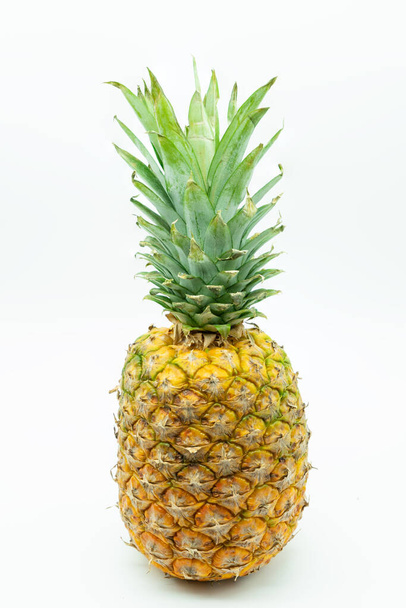 Pineapple 'ın yakın plan görüntüsü görüntünün merkezinde beyaz bir arkaplanda izole edilmiş. Sağlıklı gıda konsepti. - Fotoğraf, Görsel