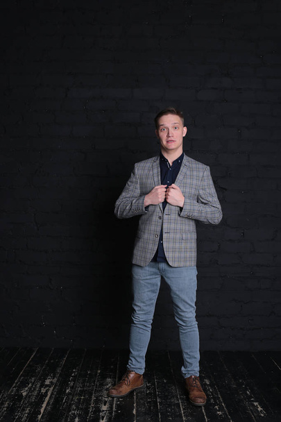 портрет эмоциональный стильный молодой человек в куртке и рубашке на темном фоне
 - Фото, изображение