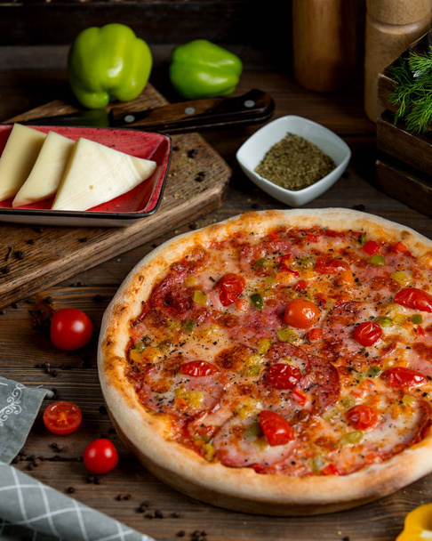 pepperoni pizza with tomato bell peppers herbs and cheese - Foto, afbeelding