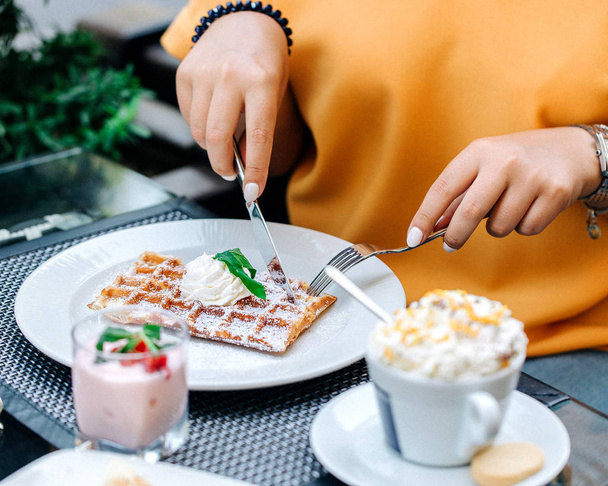 woman eating waffles topped with cream - Zdjęcie, obraz