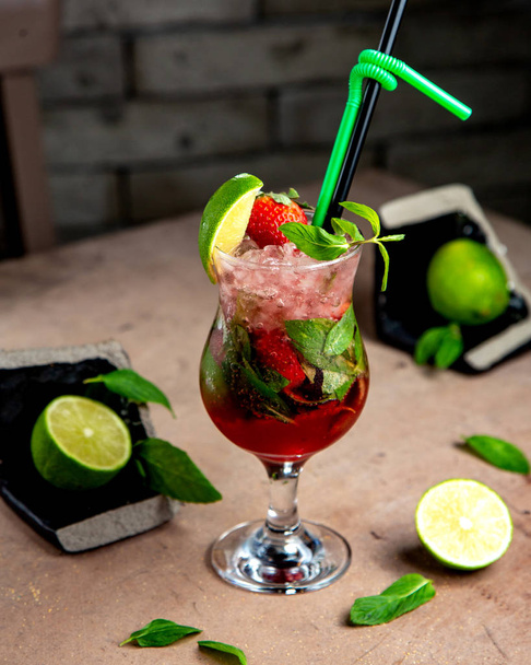 a glass of strawberry mojito with mint lime and strawberries - Foto, imagen