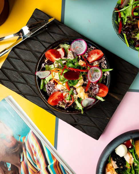 курячий салат з овочами на столі
 - Фото, зображення