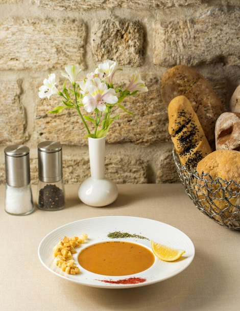 zuppa di lenticchie in piatto guarnita con limone, ripieno di pane, pepe, menta secca
 - Foto, immagini