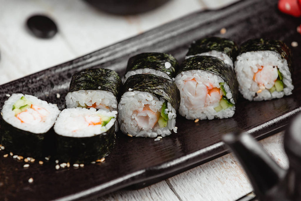 close up of nori rolls with shrimp, cucumber and rice - Foto, afbeelding