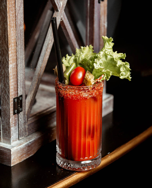 tomato cocktail garnished with lettuce cucumber pickle pepper and cherry tomato - Фото, изображение