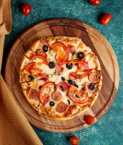 crispy pizza with tomatoes and olives and sausages - Fotó, kép