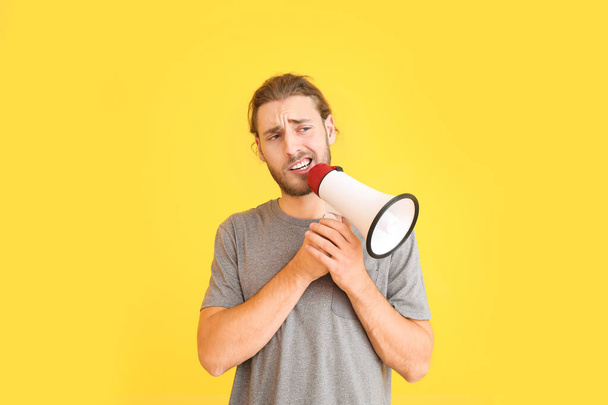 Young man with megaphone on color background - Photo, Image