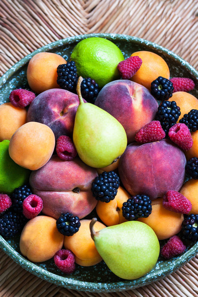 Тарілка різних літніх свіжих стиглих ягід і фруктів, крупним планом
 - Фото, зображення