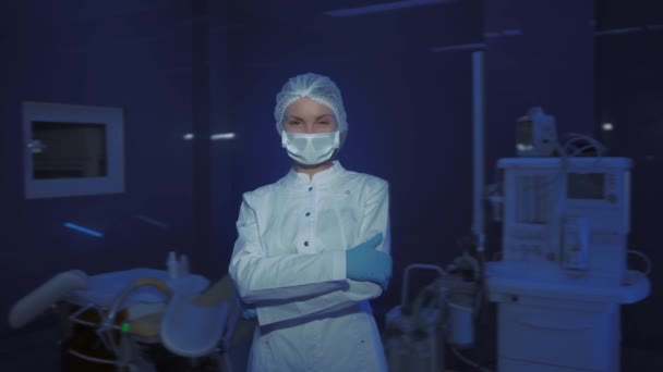 portret młodej lekarki w masce medycznej patrzącej w kamerę - Materiał filmowy, wideo