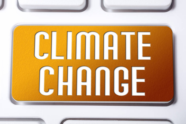 Botão laranja de mudança climática em um teclado branco, conceito futuro frágil
 - Foto, Imagem