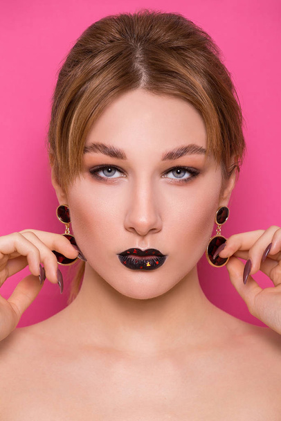 A beautiful young girl of European appearance with beautiful make-up on a pink background. Beauty Shooting - Foto, Imagen