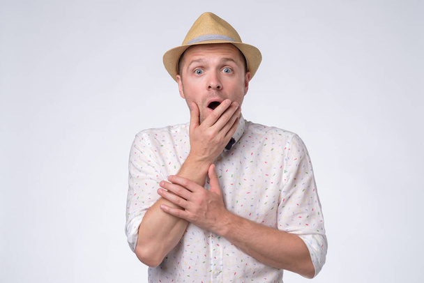 Young handsome man in summer hat having surprised facial expression - Foto, Imagen