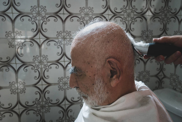 80 éves férfi kap hajvágás unokája a régi Vintage stílusú fürdőszoba - Fotó, kép