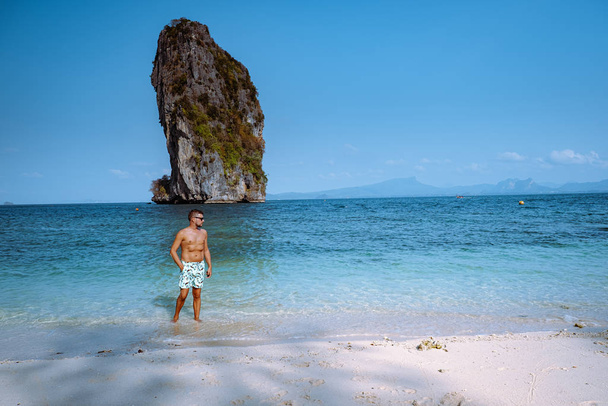 jeunes hommes sur la plage de Koh Poda Thaïlande, Le beau paysage de Koh Poda ou Poda Island dans la province de Krabi en Thaïlande. Cette île a une plage de sable blanc et entourée d'eau cristalline
 - Photo, image