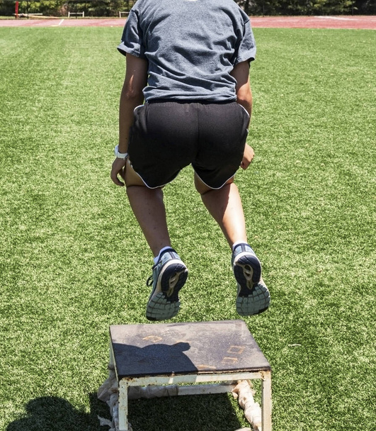 Vista trasera del atleta saltando a una caja de plyo
 - Foto, Imagen