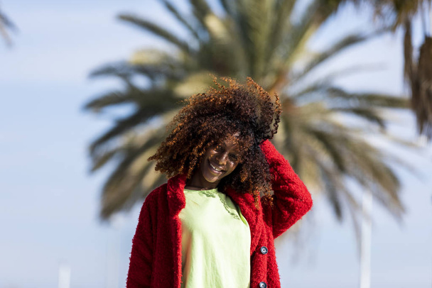 Portrait of a beautiful afro american woman standing in the street in a sunny day - Foto, Bild