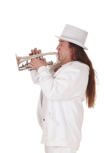 Trumpetisti seisoo valkoisessa asussa ja sylinterissä
 - Valokuva, kuva