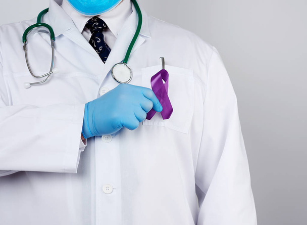 férfi orvos egy fehér kabát és nyakkendő áll, és tartja a lila si - Fotó, kép